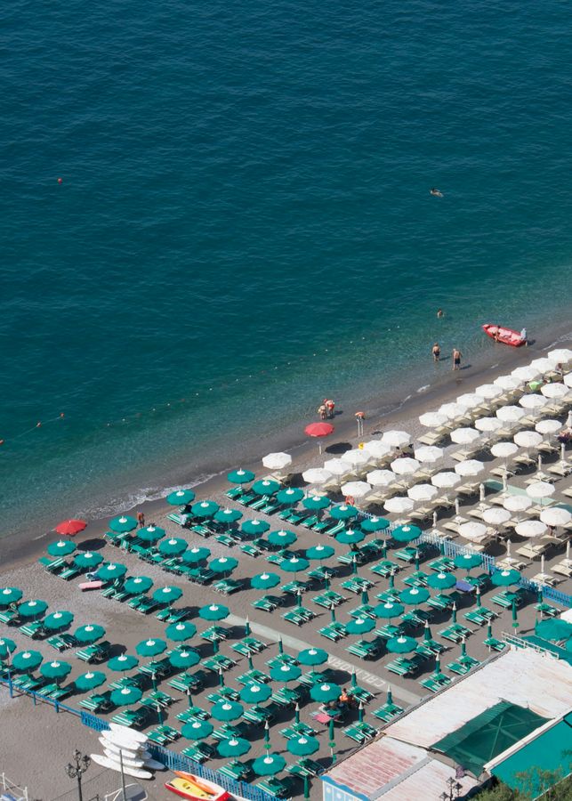 Green and white beach umbrellas seen from above at Positano