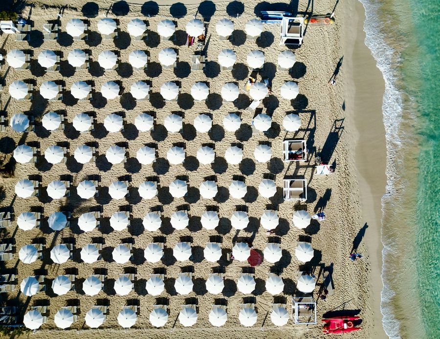 Rows of green beach umbrellas seen from above at San Vito Lo Capo